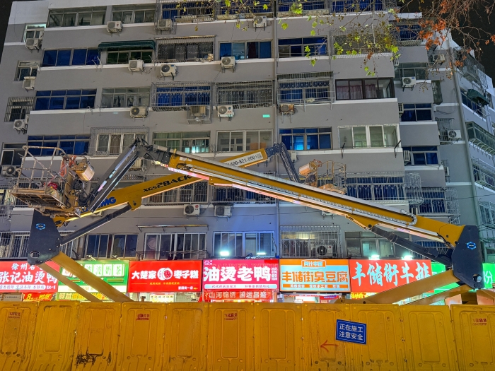 穿街过巷的“刷新艺术家”！w66利来电动直臂高空作业平台精准施技丰储街刷新